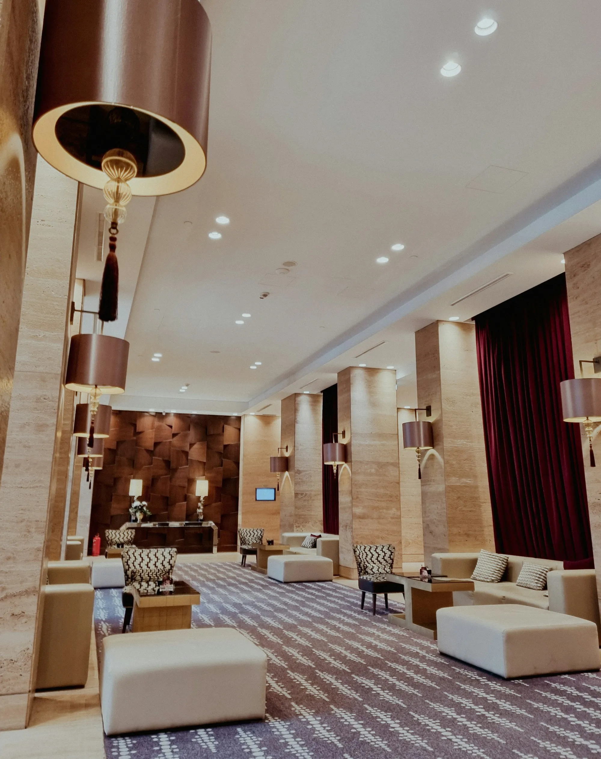 Hotellobby mit Sesseln, Teppich und warmem Licht